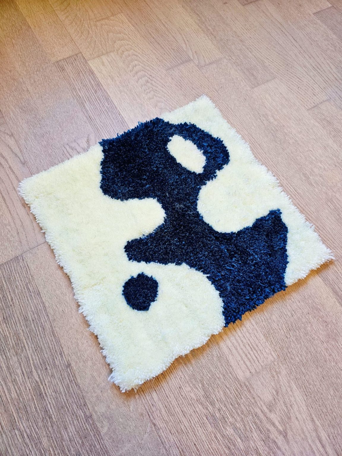 a weird shaped rug with green and white colors